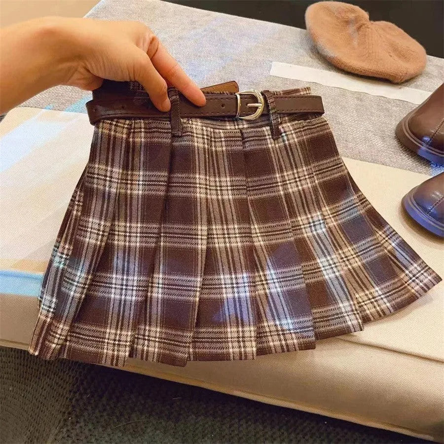 Girls' red and black plaid pleated A-line skirt on a hanger, showing cotton lining.
