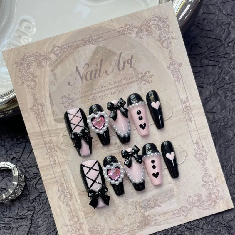 Black and pink heart hand-painted detachable artificial nails with bow design, shown in sizes XS, S, M, L.