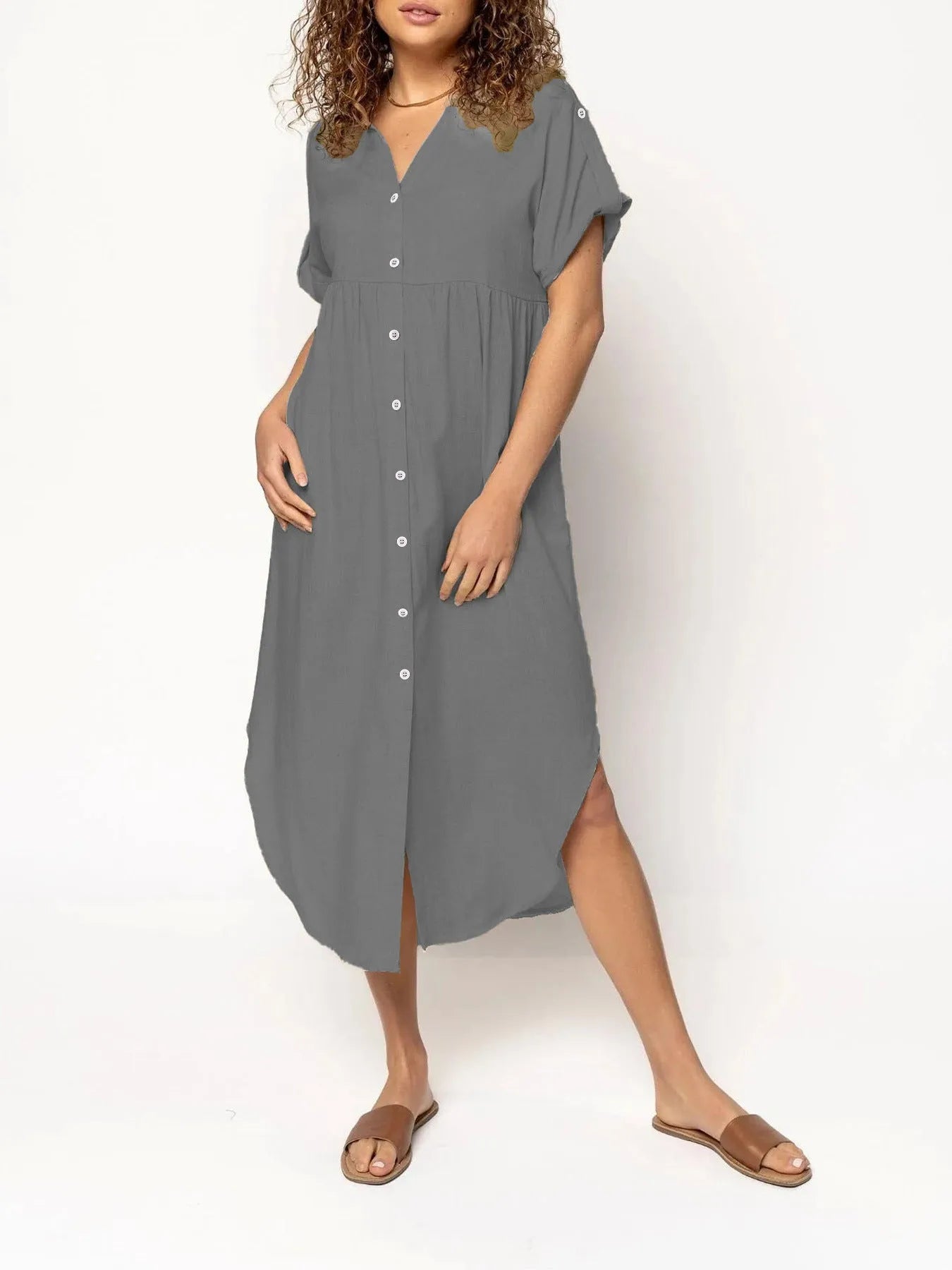 A loose-fitting, solid colour mid-length casual dress with a button-down front and regular sleeves.