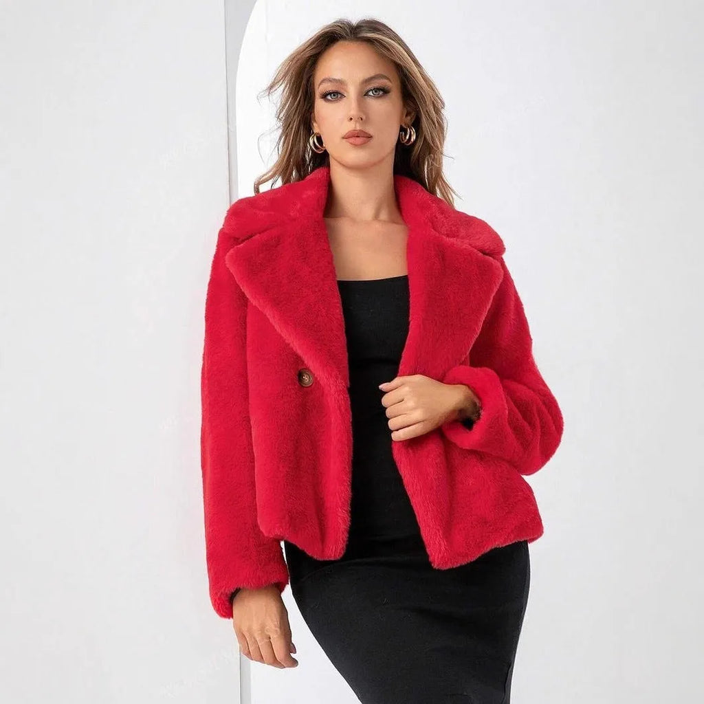 Loose short women's coat in rose red faux fur with regular sleeves on a hanger.
